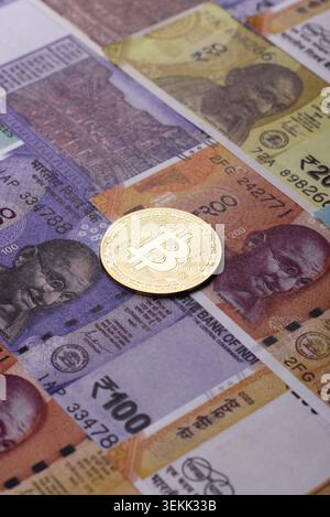 A conceptual financial background featuring Bitcoin against the Indian currency, the Rupee. Bitcoin on the Indian currency, the Rupee, as a background Stock Photo