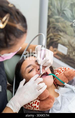 Dentist performing dental treatment on young patient's teeth Stock Photo