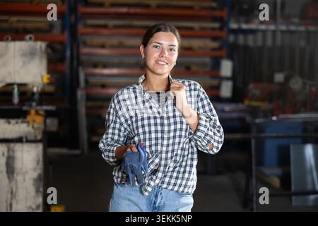 Portrait of positive female worker in workshop of metallurgical plant Stock Photo