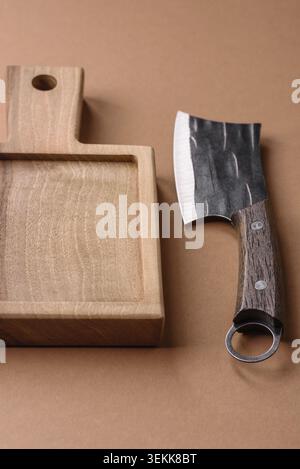 Empty wooden cutting board with a knife, salt, and spices for food preparation. An empty wooden cutting board as a food background for your design Stock Photo