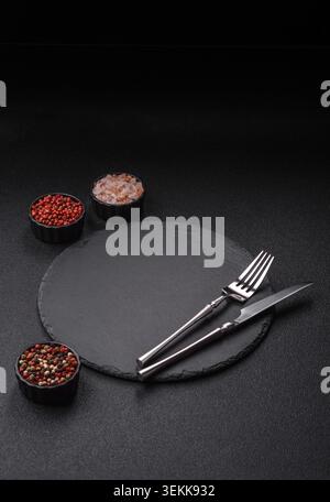 An empty slate cutting board with cutlery on a kitchen counter. Slate cutting board, food background for your design Stock Photo