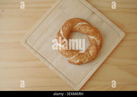 Freshly baked turkish simit roll on a wooden cutting board Stock Photo