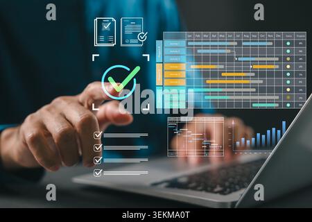 Project manager plans work using Gantt chart schedule, utilizes dashboard for corporate timeline, shows deliverables on laptop screen, hand touches ch Stock Photo