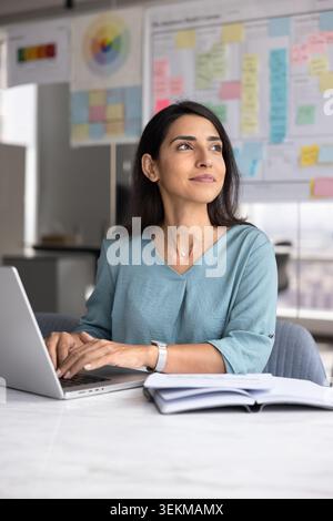 Pensive businesswoman working on laptop in office Stock Photo