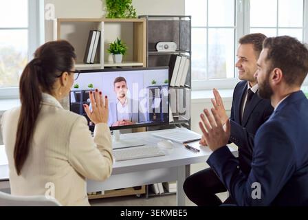 Business team in office having online video conference call with remote colleague Stock Photo