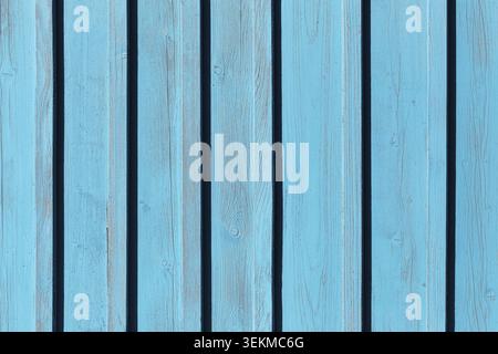 Blue painted wooden fence texture background with vertical planks. Decorative exterior surface pattern and construction material. Stock Photo