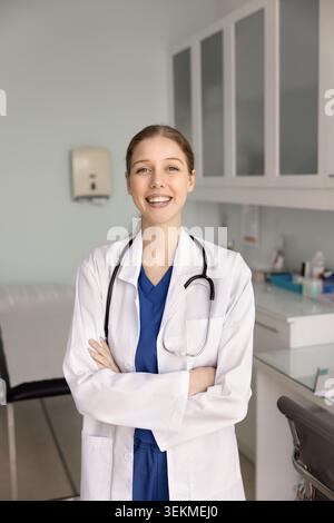 Portrait of confident female doctor in coat standing in clinic Stock Photo