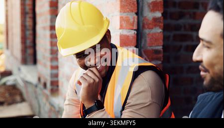 Happy, men and construction workers in conversation on site for home renovation in collaboration. Laugh, break and male civil engineers in discussion Stock Photo