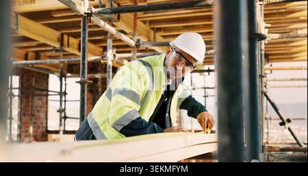 Man, carpenter and construction with measuring tape for woodwork, production or building design. Male person, contractor or industrial artisan with Stock Photo