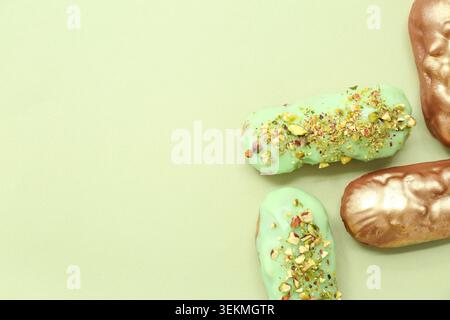 Composition with tasty glazed eclairs on color background Stock Photo