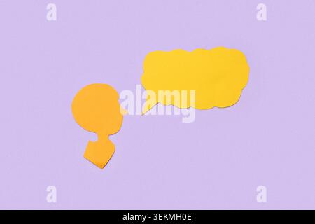 Paper human head and blank speech bubble on lilac background Stock Photo