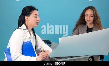 Team of smart clever women specialists analyzing construction layouts and docume Stock Photo