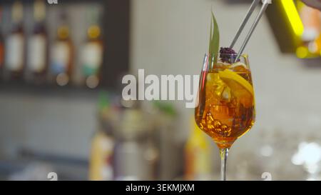 Skilled bar employee pouring refreshing beverage into elegant cocktail glassware Stock Photo
