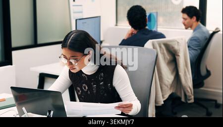 Business, woman and document with laptop in office for research, inquiry and insurance for finance. Reading, person and coworking with pc for Stock Photo