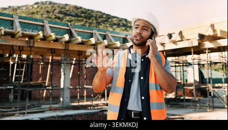 Man, architect or talking with phone call on construction site for building development or planning. Male person, contractor or civil engineer Stock Photo