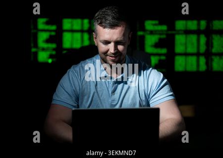 Programmer uses workstation for coding tasks. Programmer writes programming for secure network. Programmer monitors data analysis and logs. Programmer Stock Photo