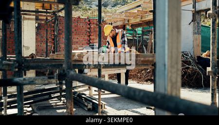 Construction, scaffolding and man with planning on site for renovation, code compliance or safety. Civil engineering, foreman and project management Stock Photo