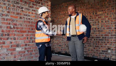 Handshake, men and construction workers on site with deal, agreement or collaboration for building. Teamwork, industry and male civil engineers Stock Photo
