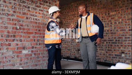 Handshake, men and civil engineers on site with deal, agreement or collaboration for building. Teamwork, industry and male construction workers Stock Photo