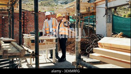 Discussion, men and construction workers on site with planning for property renovation or repairs. Conversation, professional and civil engineers in Stock Photo