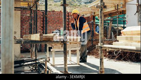 Construction, man and talk with radio on site for building inspection, hazard reporting and workflow. Project manager, black person and communication Stock Photo