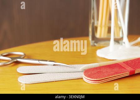 Manicure set with nail files, scissors, and cotton swabs on a wooden table. Professional grooming and self-care tools for spa and beauty themes Stock Photo