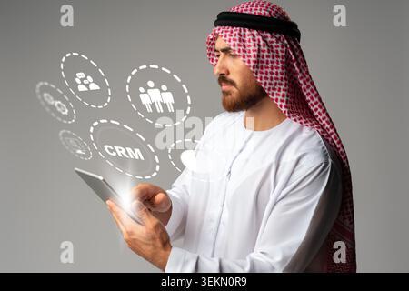 Middle Eastern man using tablet to manage customer relationship software features Stock Photo