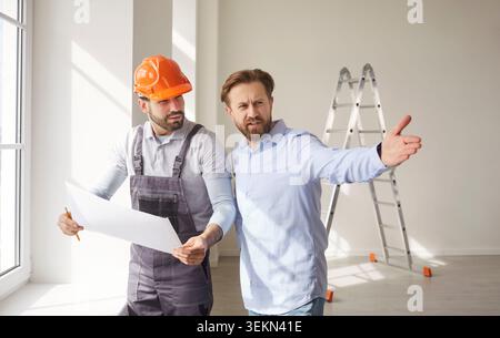 Discussing building plans, male worker holding blueprints and client gesturing, construction Stock Photo