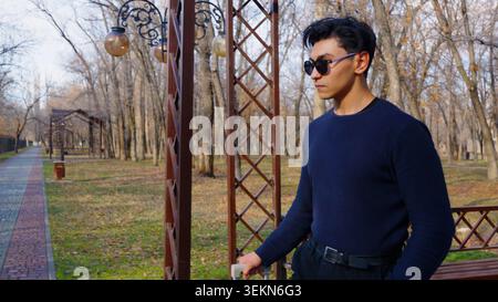 Portrait of handsome confident man wearing sunglasses standing Stock Photo