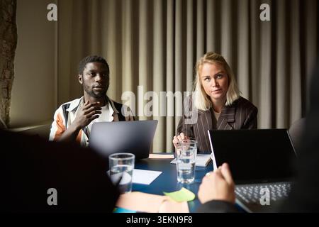 Male and female business professionals sharing ideas in team meeting at office Stock Photo