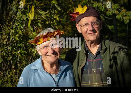 Portrait of smiling senior couple posing against plants Stock Photo