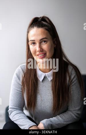 Portrait of smiling young female business entrepreneur with long hair Stock Photo