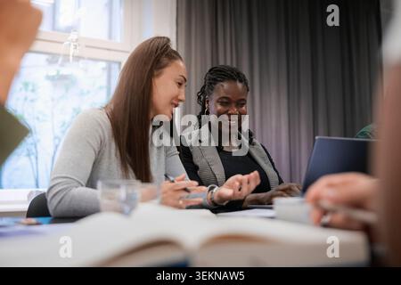 Multiracial female colleagues talking with each other in meeting at office Stock Photo