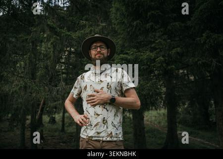 Portrait of smiling man wearing hat standing in forest Stock Photo