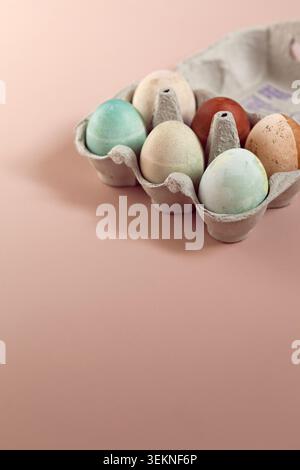 Colorful Easter Eggs arranged in tray over beige background Stock Photo