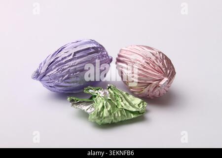 Two pastel colored chocolate Easter eggs and a foil wrapper. Stock Photo