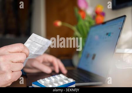 Close-up of man reading prescription before taking medicines at home Stock Photo