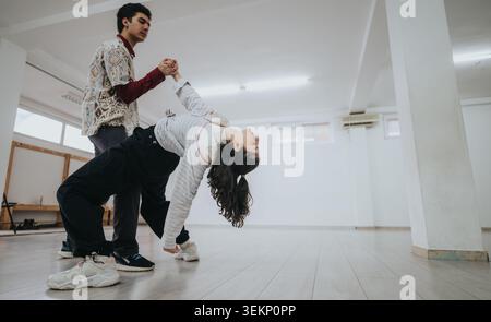 Two dancers practicing a partner contemporary dance pose in a bright studio space Stock Photo
