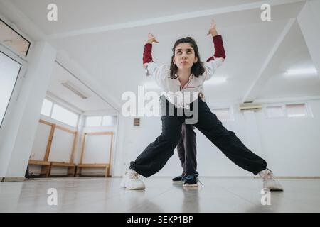 Two contemporary dancers practicing a partnered pose in a bright studio during rehearsal session Stock Photo