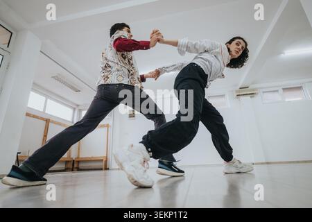 Two dancers practicing a contemporary partner routine in a bright dance studio space Stock Photo