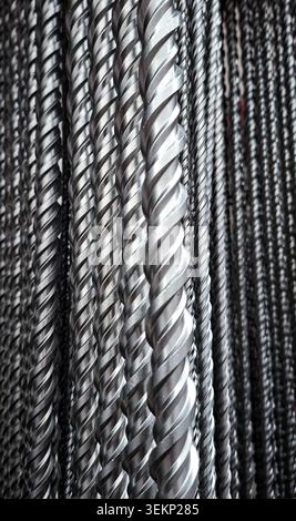 Long steel drill bits are lined up in a row, showing the spiral flutes. These tools are used for metalworking and precision engineering in various man Stock Photo