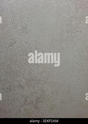 Wall covering features a textured design in neutral beige and taupe shades. The subtle grainy plaster effect adds depth to interior spaces, suitable f Stock Photo