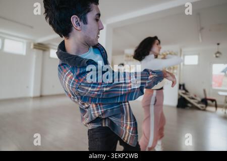 Young dancers rehearsing a contemporary partner routine in a bright dance studio Stock Photo