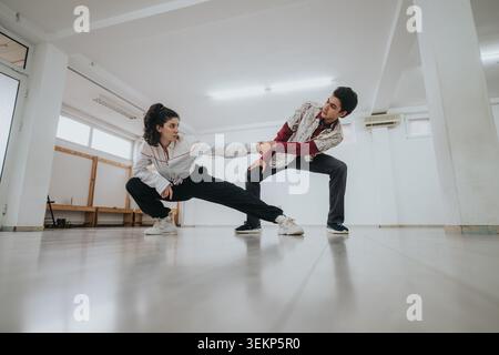 Two young dancers practicing a partnered contemporary routine in a bright rehearsal studio Stock Photo