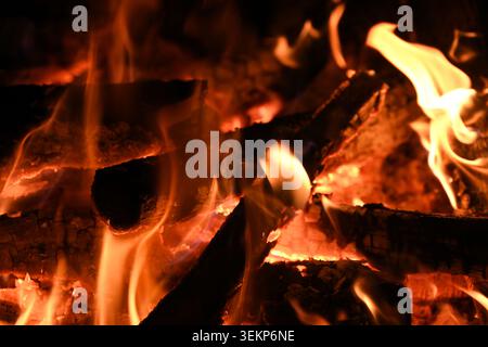 Close-up of burning wood flames in a cozy fire showing heat, warmth and glowing embers Stock Photo
