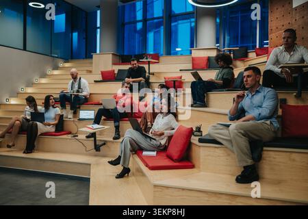 Business team collaborating in modern tiered office space during informal meeting and brainstorming session Stock Photo