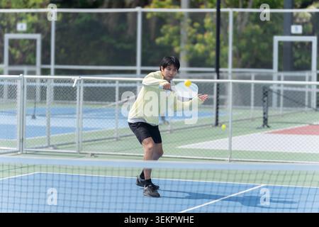 Active Diverse People Playing Pickleball on Outdoor Court Stock Photo