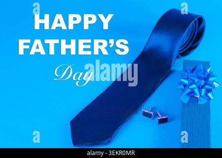 Blue necktie, cufflinks and gift box arranged in a stylish flat lay on a blue background. Elegant men’s accessories concept for Father’s Day, gifts, Stock Photo