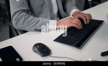 Cropped view male hands typing computer using mouse browsing internet chatting e-mail virtual chat unrecognizable business man working with pc device Stock Photo