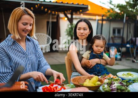 Multi ethnic family enjoying backyard barbecue picnic together Stock Photo